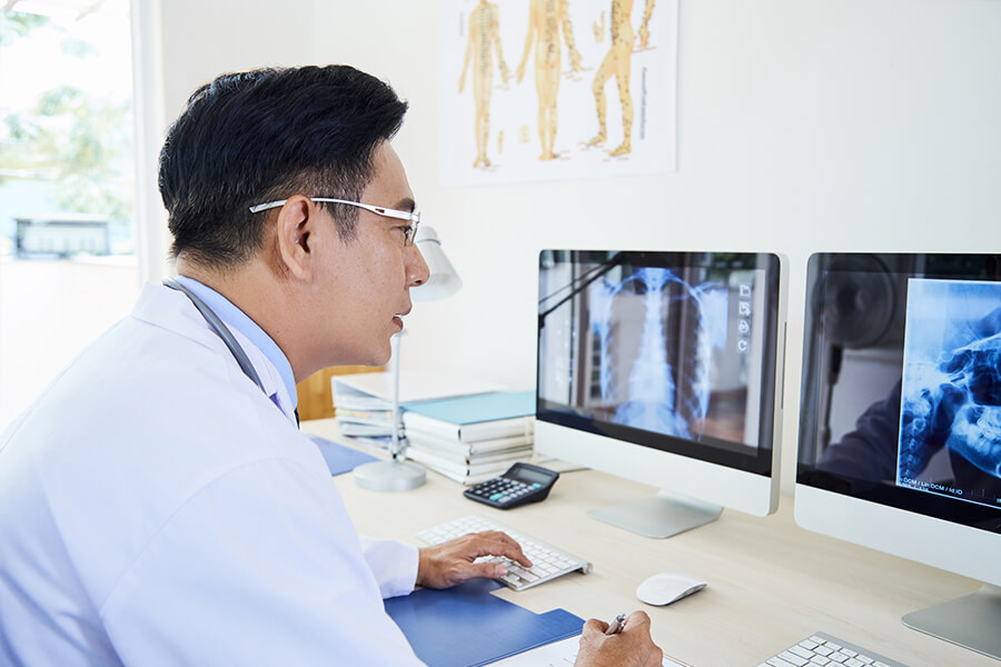GP comparing xray images on computer screen